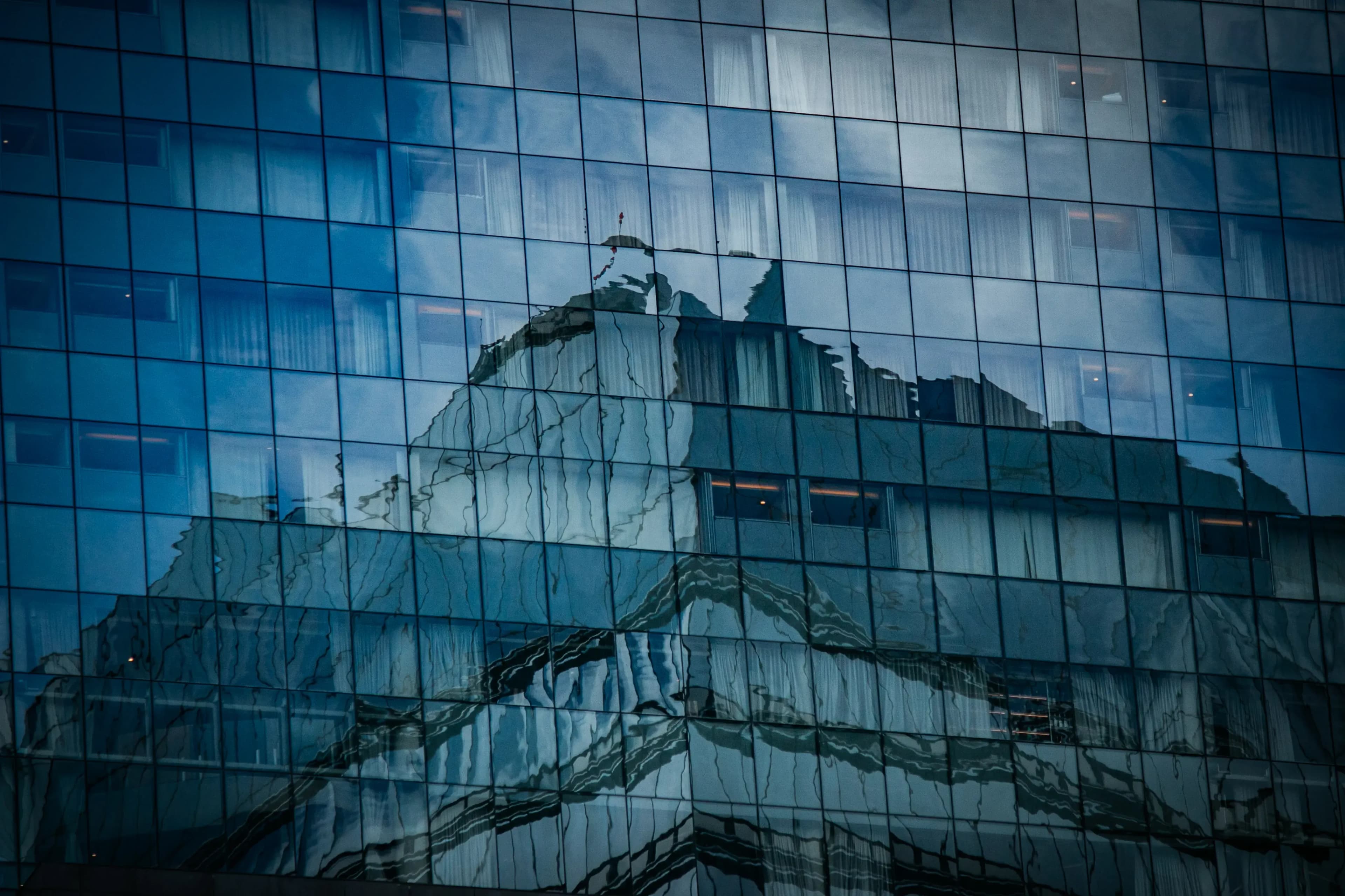 Abstract close-up of a glass building facade reflecting the sky