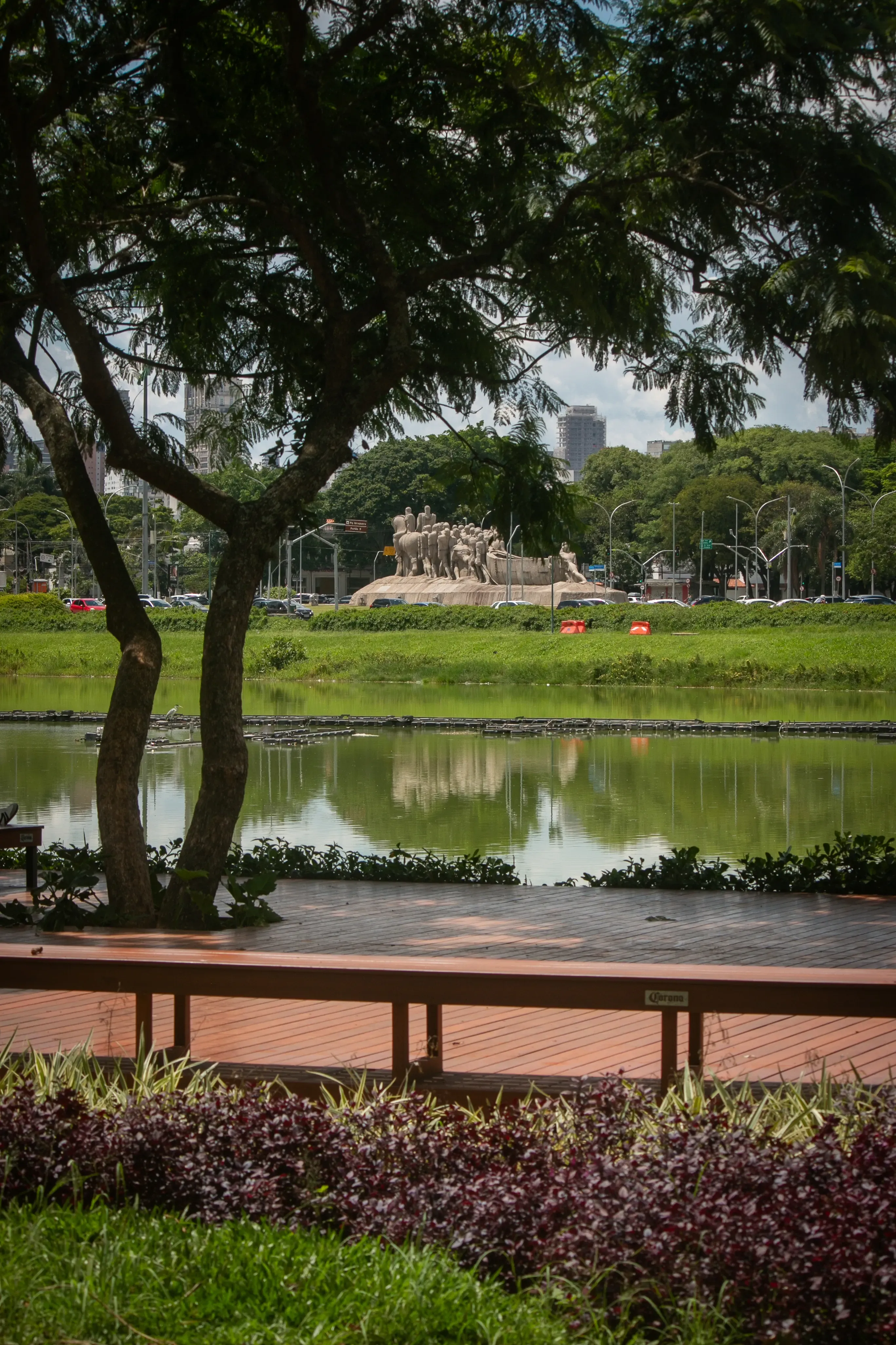 Lake in Ibirapuera Park with a monument in the background among trees