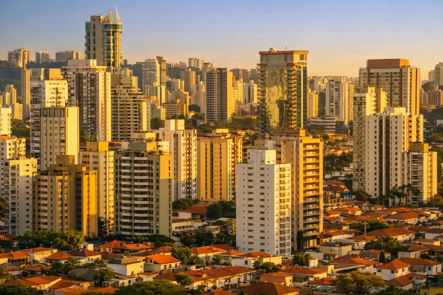 Dense city skyline of tall residential buildings glowing in late-afternoon sunlight