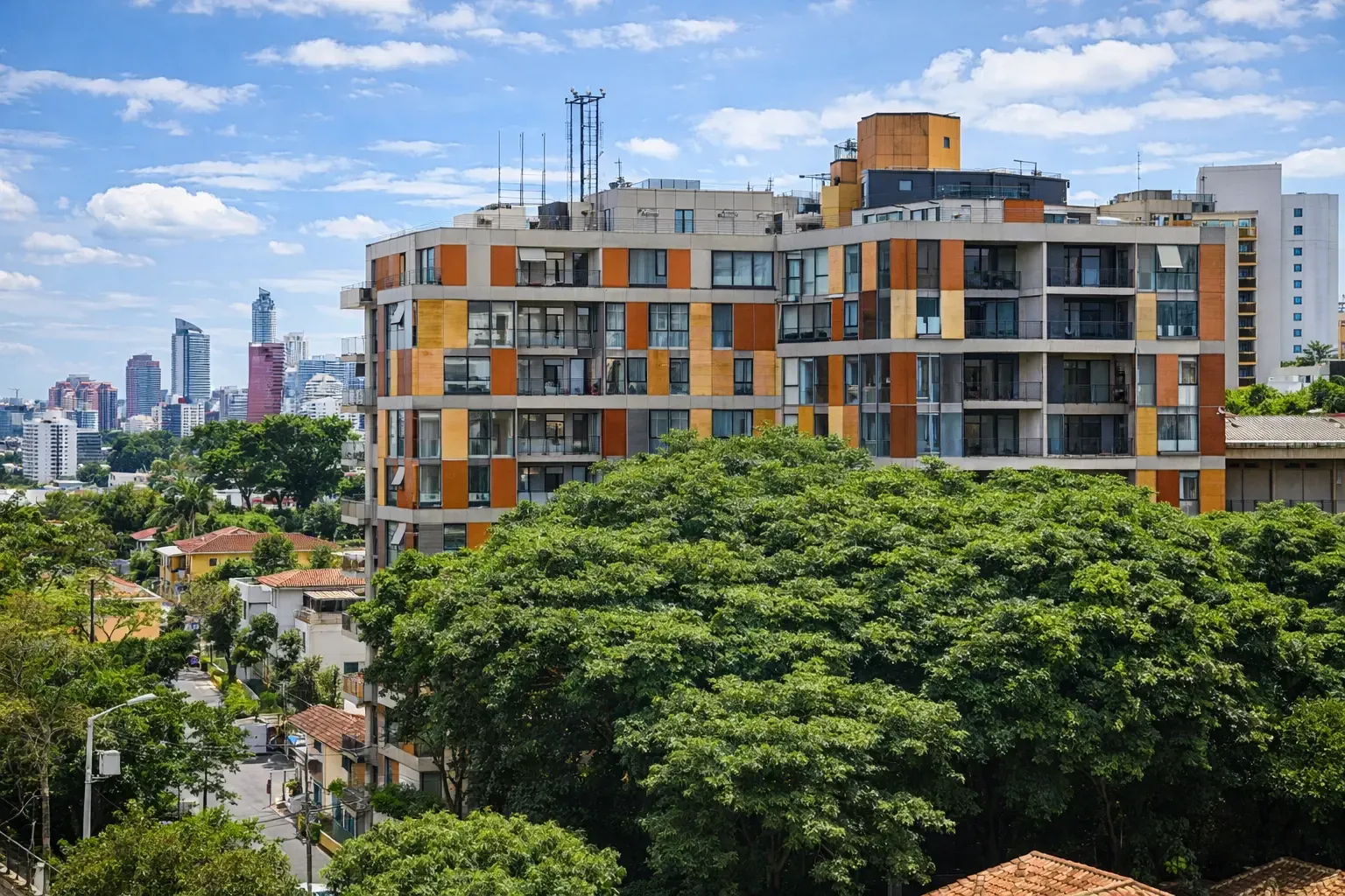 Contemporary apartment building with warm-toned facade above dense green treetops